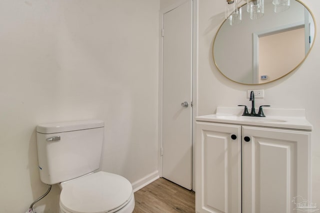 bathroom with hardwood / wood-style floors, vanity, and toilet