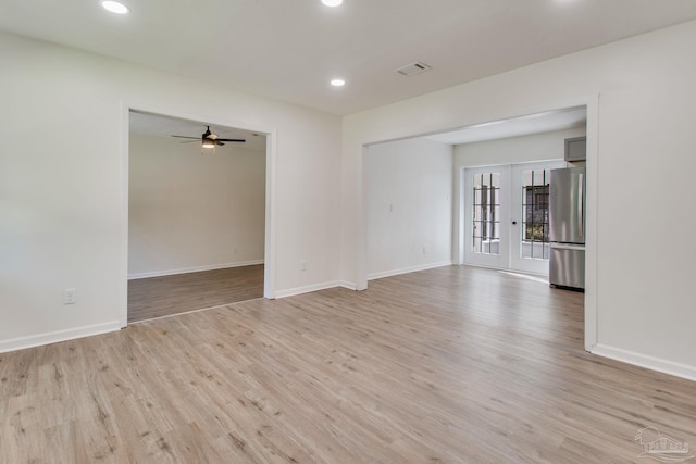 spare room featuring ceiling fan, french doors, and light wood-type flooring