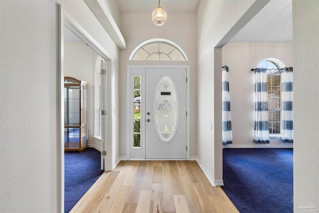 foyer entrance featuring a textured ceiling and light wood-type flooring