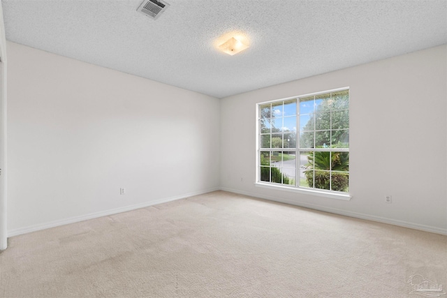 carpeted empty room with a textured ceiling