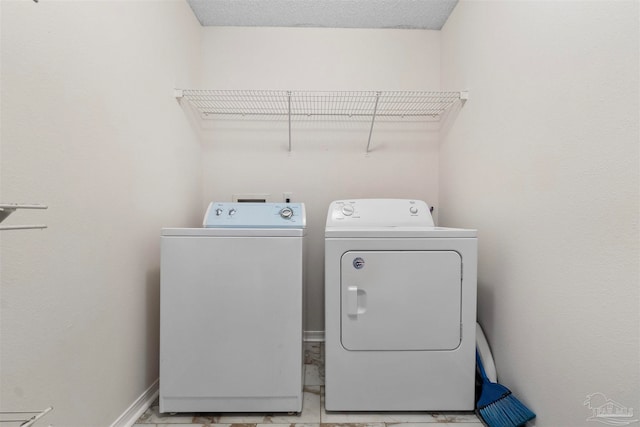 clothes washing area with a textured ceiling and washing machine and clothes dryer