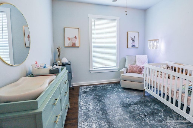 bedroom featuring a crib and dark hardwood / wood-style floors