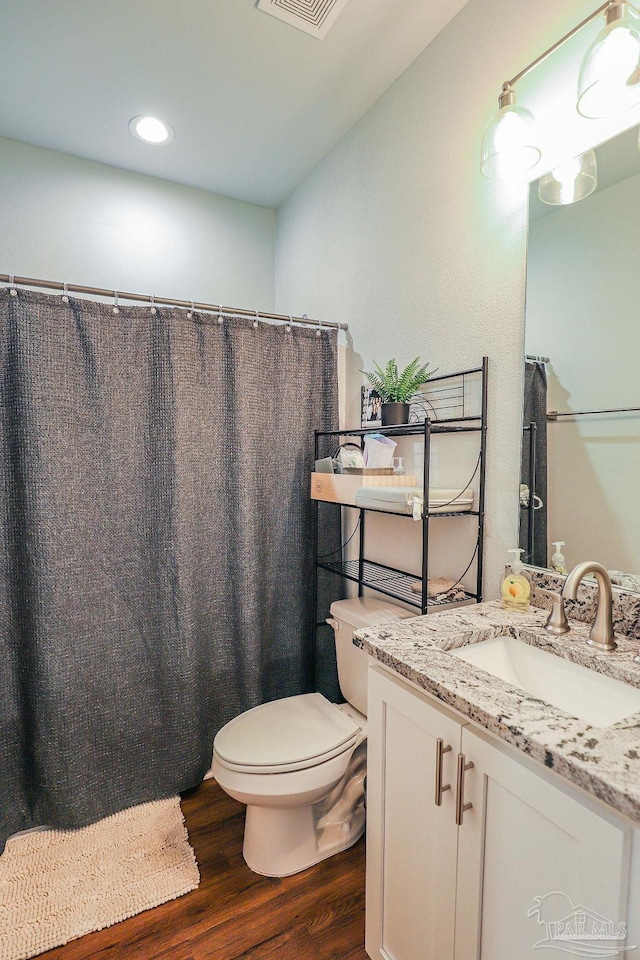 bathroom featuring toilet, wood-type flooring, and vanity