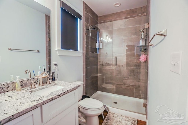 bathroom featuring toilet, walk in shower, and vanity