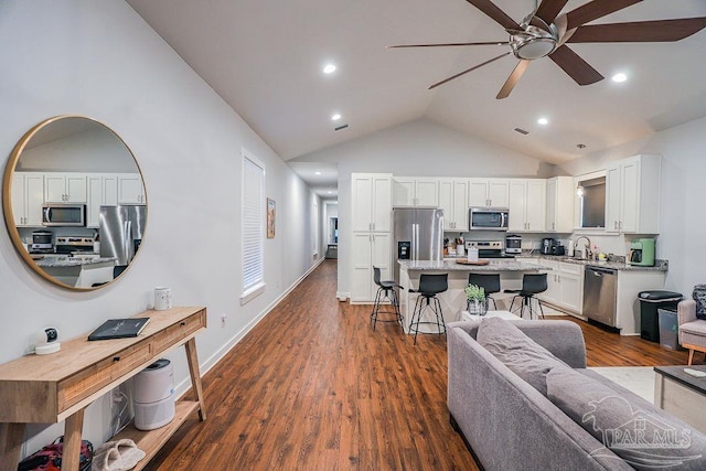 living room featuring dark wood-type flooring, high vaulted ceiling, and ceiling fan