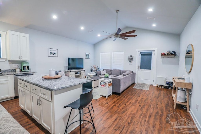 kitchen with white cabinets, a center island, vaulted ceiling, and dark hardwood / wood-style floors