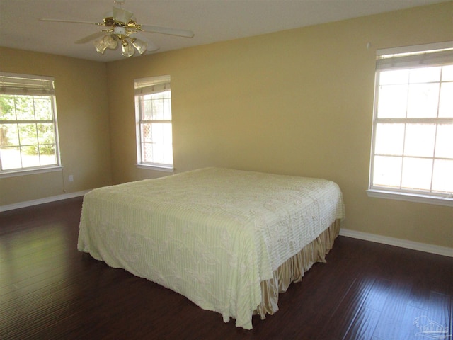 bedroom with dark wood-type flooring, baseboards, and a ceiling fan
