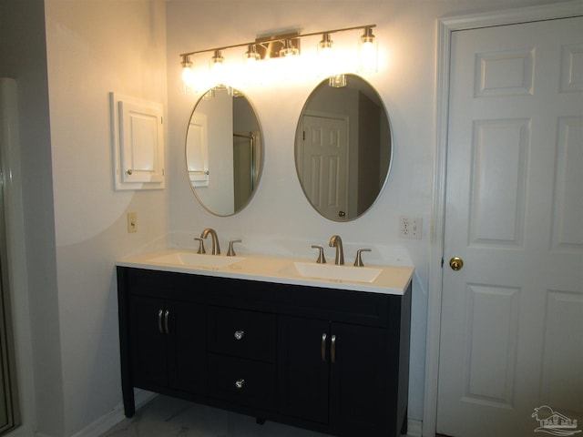 full bath with a sink, double vanity, and marble finish floor