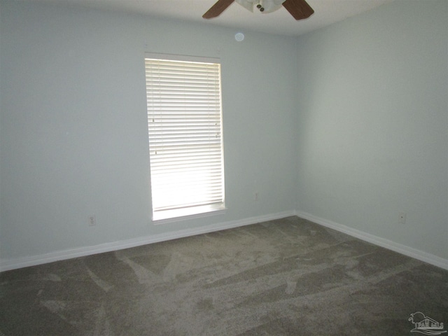 carpeted spare room with baseboards and a ceiling fan