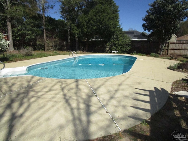 view of swimming pool featuring fence, a fenced in pool, and a patio