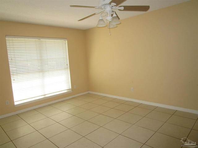 unfurnished room with light tile patterned floors, baseboards, and ceiling fan