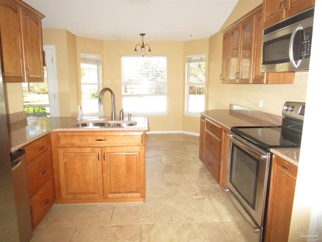 kitchen with a peninsula, a healthy amount of sunlight, a sink, and stainless steel appliances