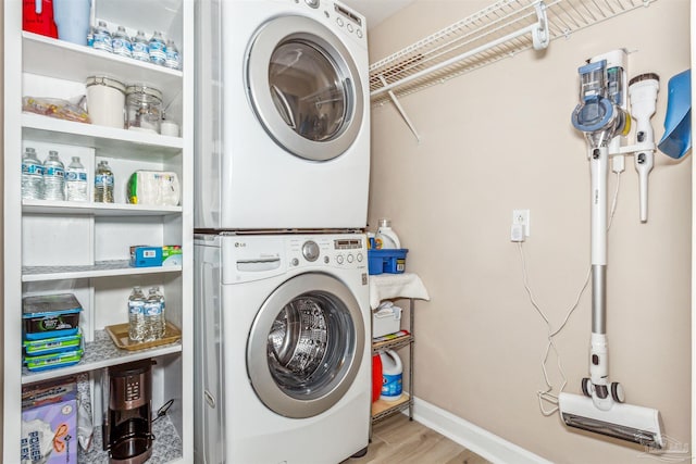 clothes washing area with light hardwood / wood-style flooring and stacked washing maching and dryer