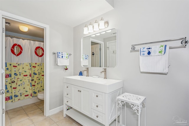 bathroom featuring toilet, vanity, and tile patterned flooring