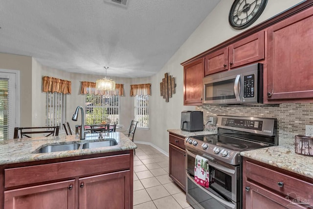 kitchen featuring pendant lighting, an inviting chandelier, sink, light tile patterned floors, and stainless steel appliances