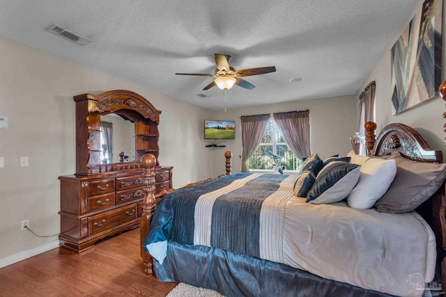 bedroom featuring hardwood / wood-style floors, a textured ceiling, and ceiling fan