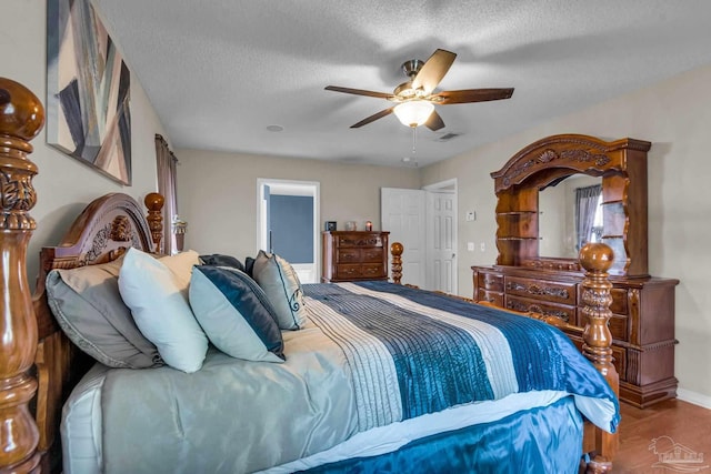 bedroom featuring ceiling fan, wood-type flooring, and a textured ceiling