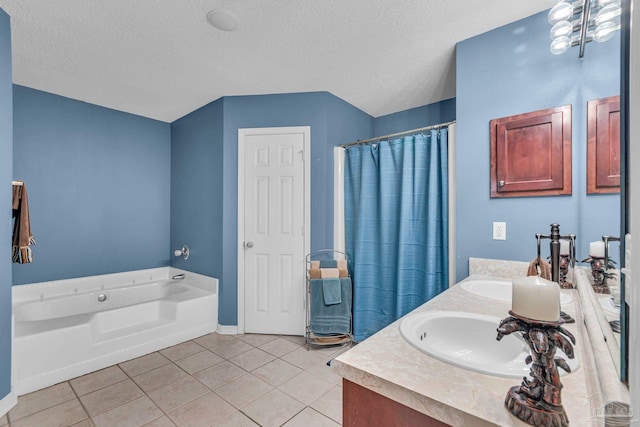 bathroom with vanity, a bath, a textured ceiling, and tile patterned floors