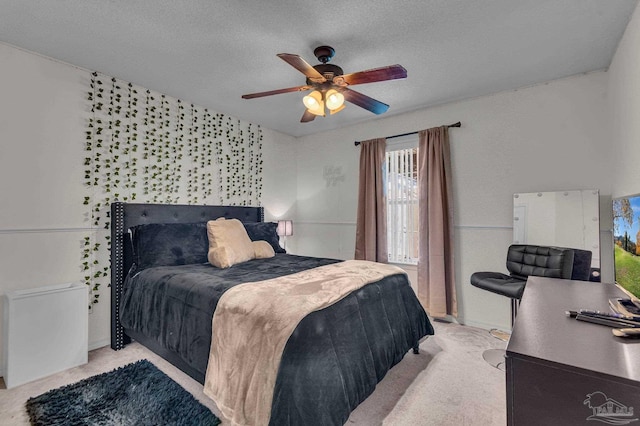 bedroom with ceiling fan, light carpet, and a textured ceiling