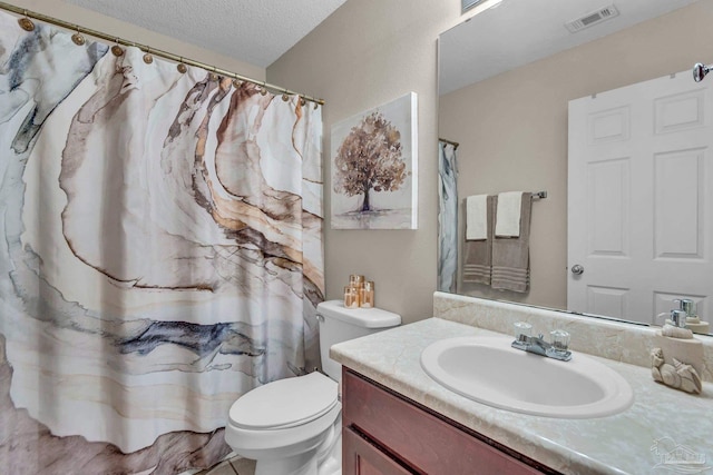 bathroom with vanity, a textured ceiling, and toilet