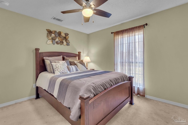 carpeted bedroom featuring a textured ceiling and ceiling fan