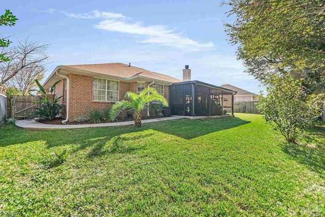 back of house featuring a lawn and a sunroom