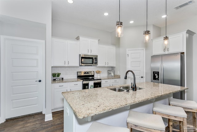 6610 Delhi Dr, Milton, FL 32583 - kitchen featuring stainless steel appliances, dark wood finished floors, a kitchen bar, tasteful backsplash, and recessed lighting