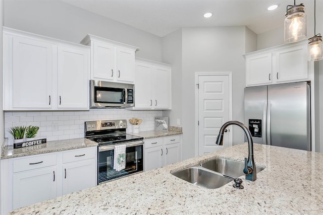 6610 Delhi Dr, Milton, FL 32583 - kitchen with stainless steel appliances, white cabinetry, tasteful backsplash, decorative light fixtures, and light stone countertops
