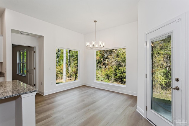 6610 Delhi Dr, Milton, FL 32583 - unfurnished dining area featuring light wood-type flooring, a chandelier, and healthy amount of natural light