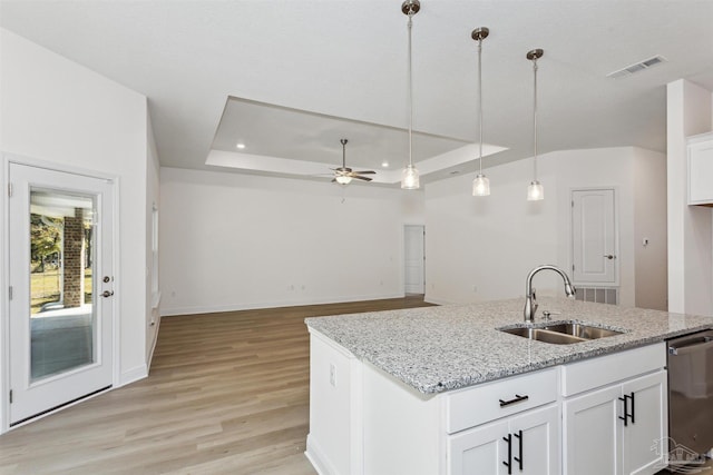 6610 Delhi Dr, Milton, FL 32583 - kitchen with a tray ceiling, stainless steel dishwasher, light wood-style floors, a ceiling fan, and white cabinetry