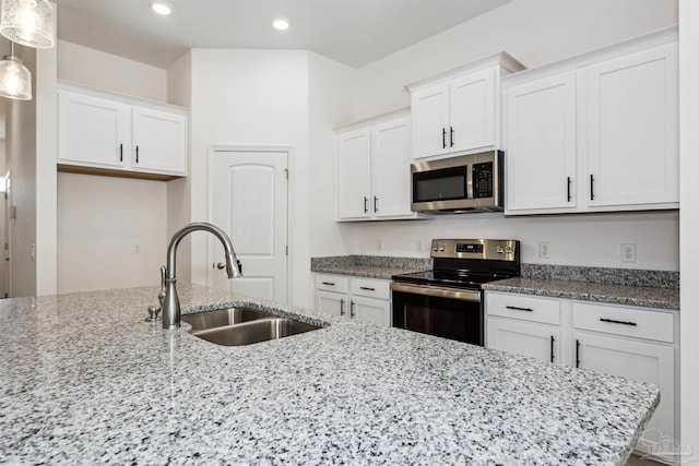 6610 Delhi Dr, Milton, FL 32583 - kitchen with appliances with stainless steel finishes, white cabinets, light stone countertops, recessed lighting, and decorative light fixtures
