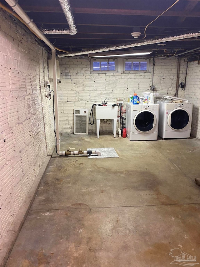 basement featuring sink and independent washer and dryer