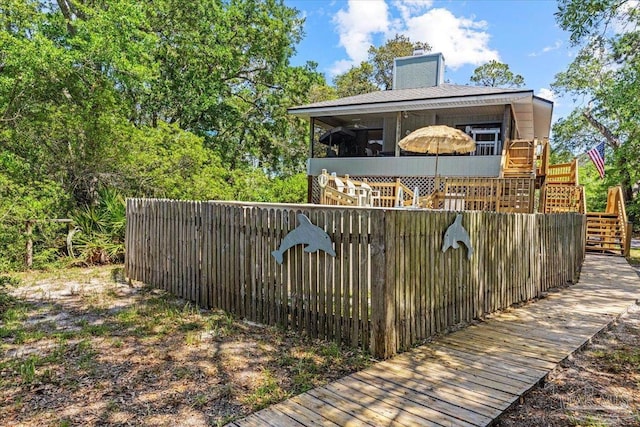 1948 Tanbark Dr, Milton, FL 32583 - exterior space featuring stairway, a chimney, a deck, a sunroom, and fence