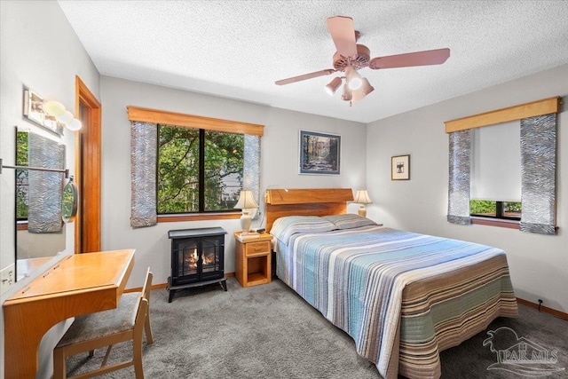 1948 Tanbark Dr, Milton, FL 32583 - bedroom featuring a wood stove, carpet floors, a textured ceiling, baseboards, and a ceiling fan