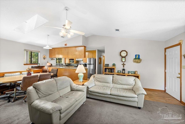 1948 Tanbark Dr, Milton, FL 32583 - living area with a skylight, ceiling fan, vaulted ceiling, light colored carpet, and baseboards