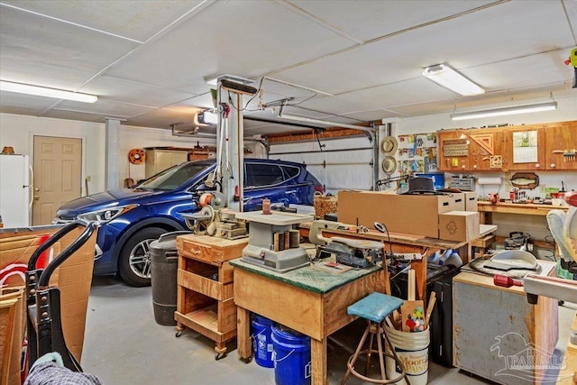 1948 Tanbark Dr, Milton, FL 32583 - garage with freestanding refrigerator, a garage door opener, and a workshop area