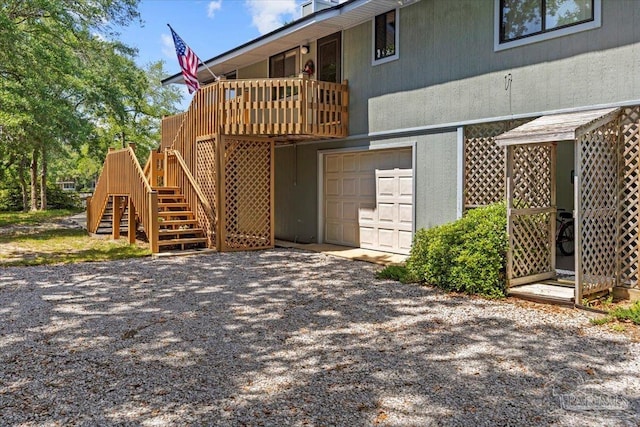 1948 Tanbark Dr, Milton, FL 32583 - back of house with an attached garage, driveway, and stairway