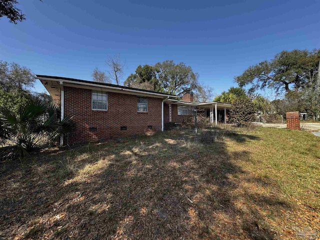 back of property with a yard and a carport