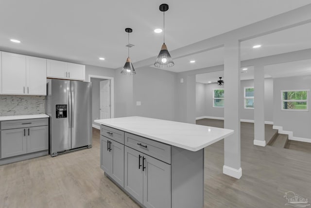 kitchen featuring gray cabinetry, decorative light fixtures, stainless steel fridge with ice dispenser, and backsplash