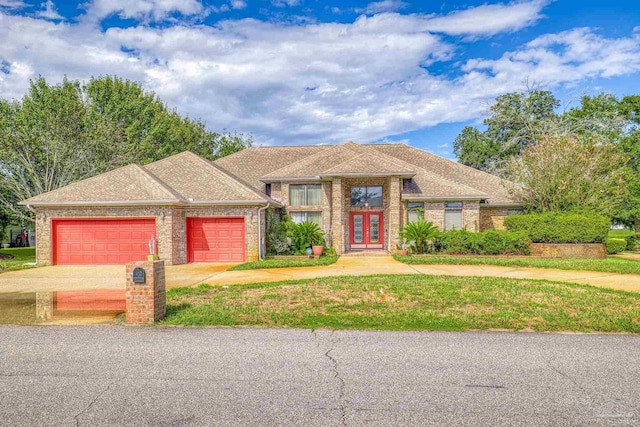 2715 Masters Blvd, Navarre, FL 32566 - view of front of house with an attached garage, french doors, concrete driveway, and brick siding