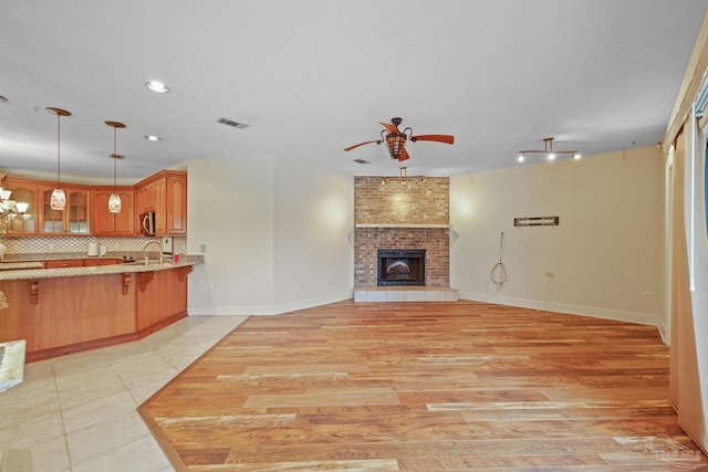 2715 Masters Blvd, Navarre, FL 32566 - unfurnished living room with ceiling fan, a fireplace, light tile patterned flooring, and recessed lighting