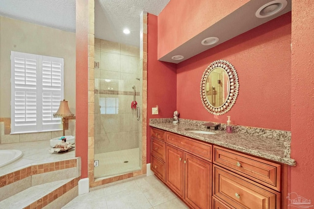 bathroom with vanity, a textured ceiling, tile patterned floors, and shower with separate bathtub