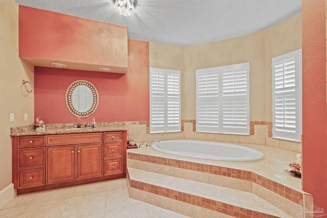 bathroom featuring a textured ceiling, vanity, tile patterned floors, and a relaxing tiled tub