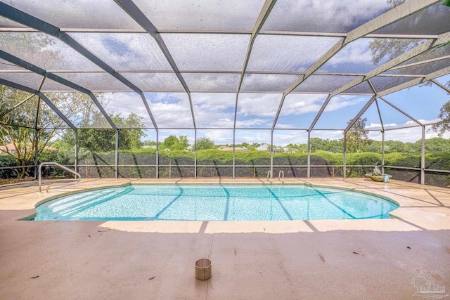 view of swimming pool featuring glass enclosure and a patio