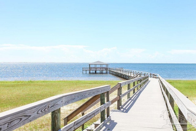 dock area with a gazebo, a yard, and a water view