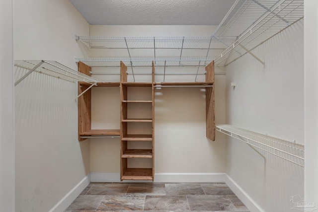 2715 Masters Blvd, Navarre, FL 32566 - walk in closet featuring stone finish flooring
