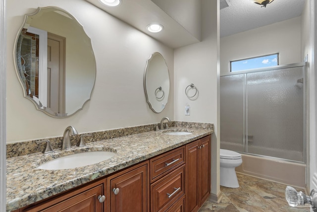 2715 Masters Blvd, Navarre, FL 32566 - bathroom featuring double vanity, shower / bath combination with glass door, stone finish floors, and a textured ceiling