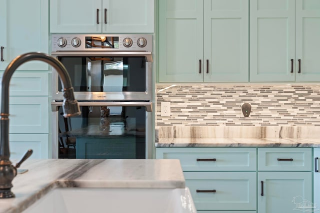 7730 Sunfish Ln, Milton, FL 32583 - kitchen with stainless steel double oven, a sink, and decorative backsplash