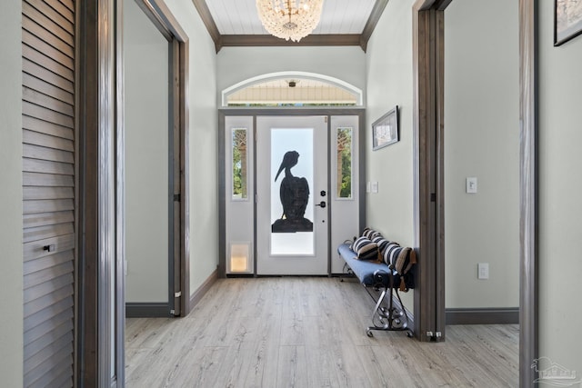 7730 Sunfish Ln, Milton, FL 32583 - foyer entrance with ornamental molding, baseboards, light wood-style floors, and a notable chandelier