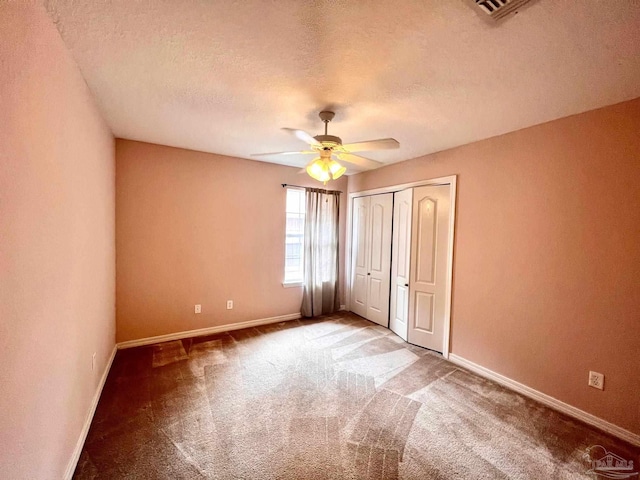 unfurnished bedroom featuring a closet, carpet flooring, a textured ceiling, and ceiling fan